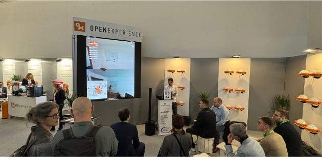 Vortrag am Open-Experience-Messestand auf der BAU 2025 vor sitzendem Publikum